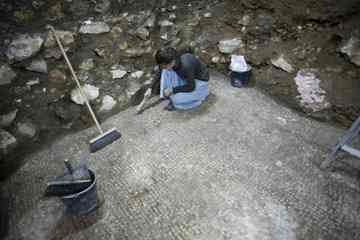 A worker of the Israel Antiquities Authority works at an excavation site in Jerusalem's Old City Monday. Israeli archaeologists preparing the ground for a new Jewish ritual bath in Jerusalem's Old City say they have made a coincidental discovery, an 1,800-year-old swimming pool built by the same Roman legion that destroyed the ancient city's hallowed second Jewish Temple. (Bernat Armangue, Associated Press)