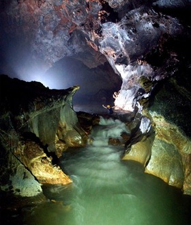 A British caver wades through Vietnam's Son Doong cave, Earth's largest known cave passage, according to a survey team. [Photograph by Barcroft/Fame Pictures]