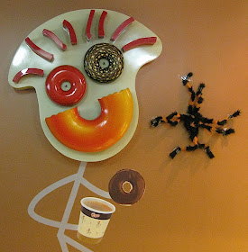 Go Nuts Donuts mascot with Halloween spider