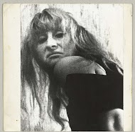 Kop van een vrouw met loshangend haar en misprijzende blik