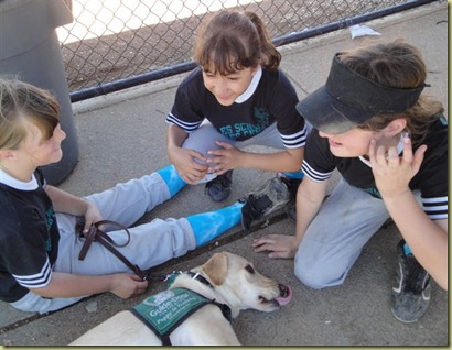 Sara holding Reyna in the dugout while they visit with some friends.