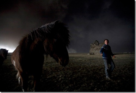 Farmer Thorarinn Olafsson tries to lure his horse back to the stable as a cloud of black ash looms overhead in Drangshlid at Eyjafjoll on April 17, 2010. (REUTERS/Ingolfur Juliusson) #