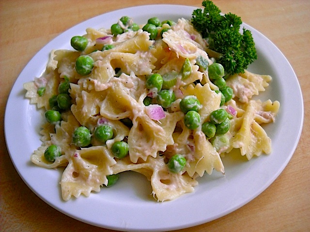 Tuna Pasta Salad with Peas plated on white plate, garnished with parsley 