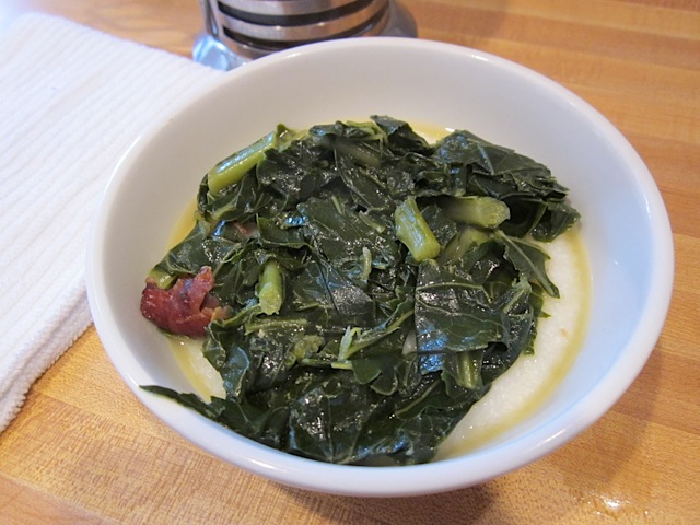 grits in white bowl with greens on top 