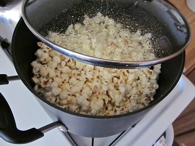 popped kernels in pot with lid propped open slightly 