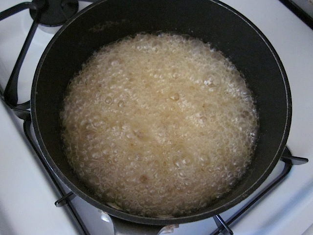top view golden sugar water in pot on stove 