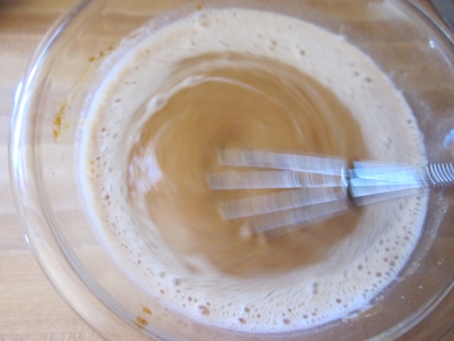 milk being whisked into pumpkin puree mixture 