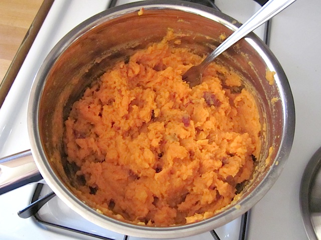 mashed chipotle sweet potatoes in mixing bowl with fork 