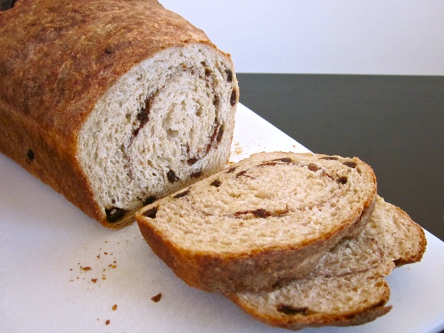 loaf of no knead cinnamon raisin bread with two slices cut 