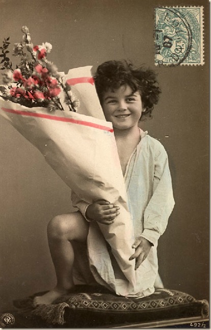 boy in blue robe with large bouquet of flowers