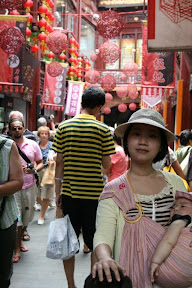 上頭的紅色竹編裝飾品和周圍的招牌掛布挺搭，倒是後邊這位遊客著了一襲小蜜蜂造型服殺了風景。