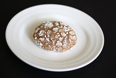 photo of one chocolate crinkle cookie on a plate