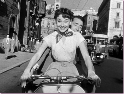 Audrey_Hepburn_and_Gregory_Peck_on_Vespa_in_Roman_Holiday_trailer