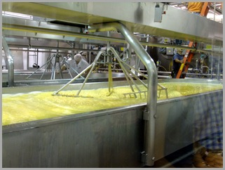 Next it is cooked and emptied into a huge vat where it is stirred