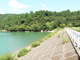 Vue de la digue côté lac du barrage depuis la rive droite.