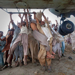 Marooned flood victims looking to escape grab the side bars of a hovering Army helicopter which arrived to distribute food supplies in the Muzaffargarh district of Pakistan\'s Punjab province August 7, 2010. Pakistanis desperate to get out of flooded villages threw themselves at helicopters on Saturday as more heavy rain was expected to intensify both suffering and anger with the government. The disaster killed more than 1,600 people and disrupted the lives of 12 million.  REUTERS/Adrees Latif  (PAKISTAN - Tags: DISASTER ENVIRONMENT IMAGES OF THE DAY)   FOR BEST QUALITY AVAILABLE: ALSO SEE GM1E68B0B8401刻唾嘿唾匼嘿居居塁奂奂坁噀匾儼