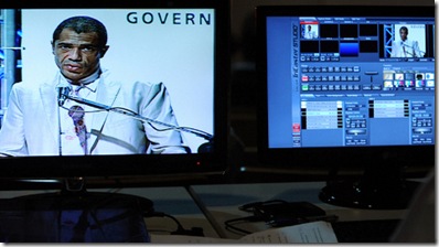 foto de um homem operando uma mesa de áudio e vídeo