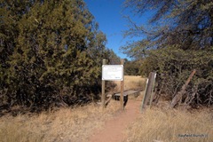 STONE CAIRN IS VISIBLE BEYOND THE SIGN