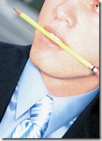 business man biting pencil