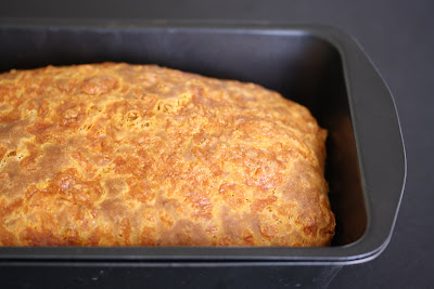 close-up photo of a loaf of Cheesy Beer Bread in a loaf pan