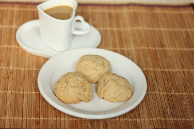 photo of a plate of three cookies and a cup of coffee