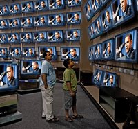 Father and son watch Obama at TV store