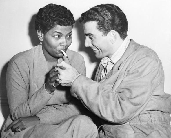 Louis Bellson lighting Pearl Bailey's cigarette, London, England, November 17, 1952.jpg