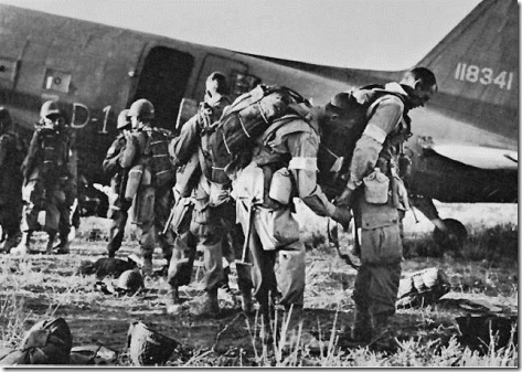 PARATROOPERS, IDENTIFIED BY WHITE ARM BANDS, preparing to emplane for Sicily.