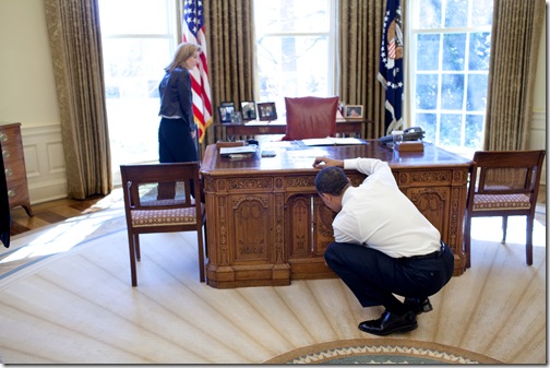 President Barack Obama examines  the Resolute Desk on March 3, 2009, while visiting with Caroline Kennedy Schlossberg in the Oval Office. In a famous photograph, her brother John F. Kennedy Jr., peeked through the FDR panel, while his father President Kennedy worked. <br />Official White House Photo by Pete Souza 