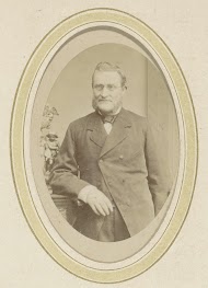 Portret van een leunende man met een baard en een bril