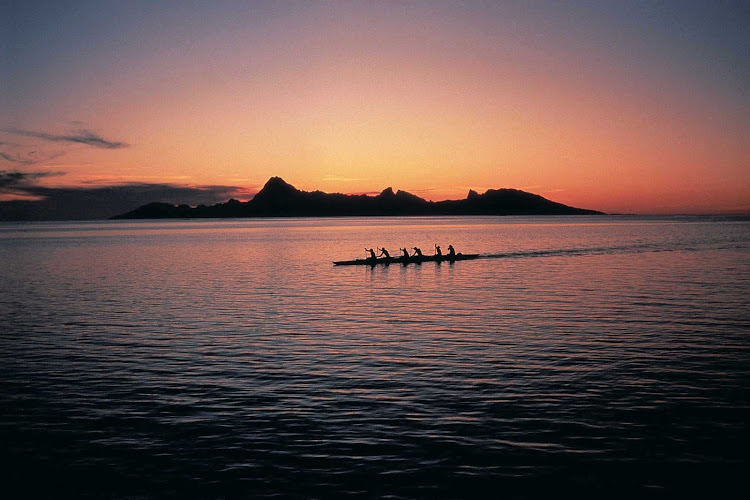 The sight of an outrigger canoe at sunset transports you back in time.