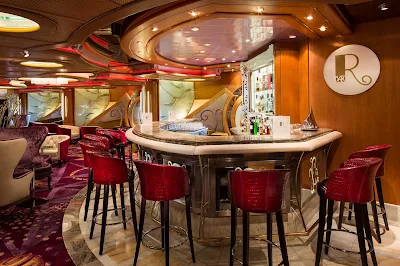 Relax and enjoy a pre-dinner drink at the R Bar aboard Navigator of the Seas.