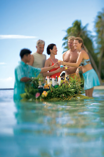 water_waiter - Paul Gauguin guests wade over to a "water waiter" along the beach at Motu Mahana.