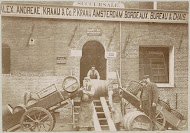 Personeel van Kraaij en Co. verricht laad- en loswerkzaamheden met vaten en karren