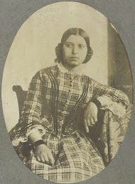 Portret van een jonge vrouw met een elleboog leunend op tafel