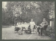 Gezelschap met An en Jan Kessler rond de tafel in de tuin van Huize De Paauw