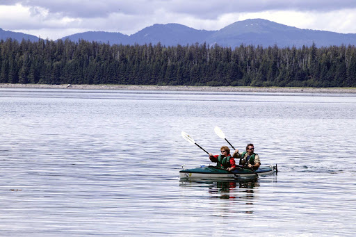 Glide through peaceful waters in a double kayak in Glacier Bay National Park, Alaska.