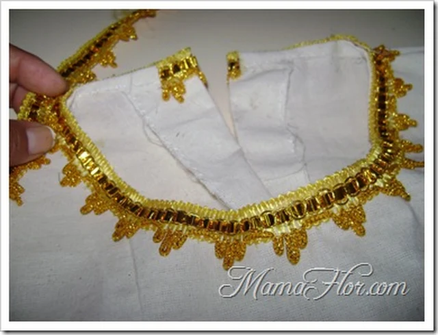 Greca dorada decorando cuello de vestido