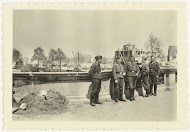 Duitse soldaten bij verwoeste huizen