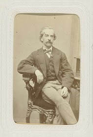 Studioportret van een man met snor in een leunstoel