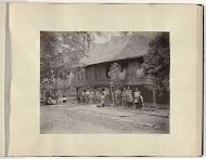 Vrouwen met kinderen voor een huis op Sumatra