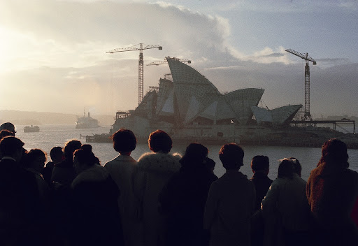 Onlookers watch the construction of the Sydney Opera House