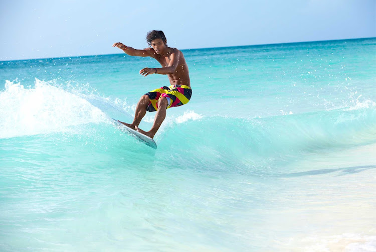 A dude shows perfect form while wave boarding on Aruba. It's a type of small surfboard.