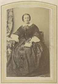 Portret van een zittende vrouw in een jurk met een boek in de hand