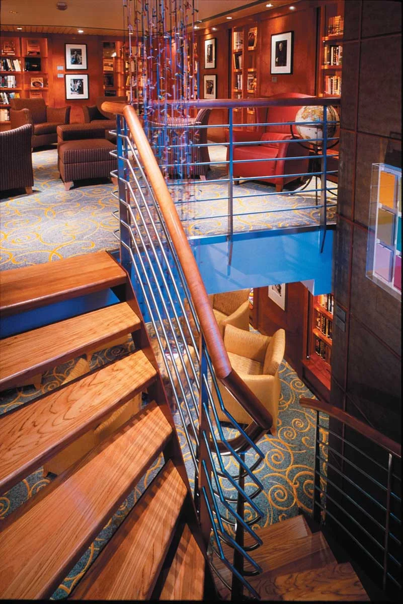 Celebrity_Millennium_Words_Library - Words, Celebrity Millennium's two-story library, features a spiral staircase, glass walls and deep armchairs. It's the ideal place to snuggle up with a good read.