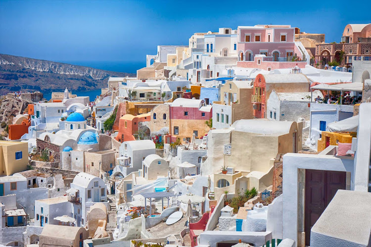 The gorgeous sugarcube village of Oia juts into the hillside of Santorini, Greece.