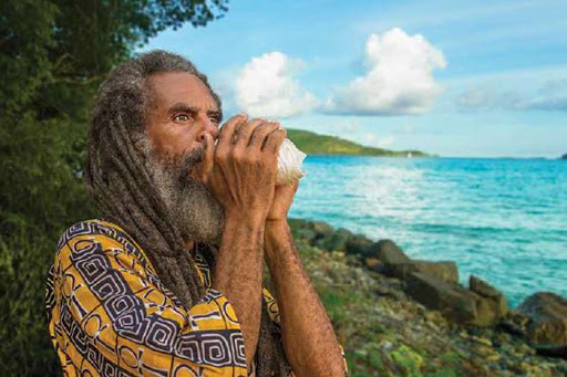 A local man shows off the tradition of blowing a conch shell on St. John in the US Virgin Islands. 