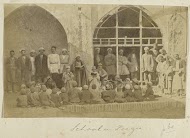 Lezende leerlingen en volwassenen op de binnenplaats van een school in Perzië