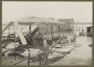 Verwoeste schuur en een huis in een ondergelopen buitenwijk van Parijs