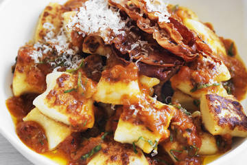 Pan-fried gnocchi with roast tomato and basil sauce and crispy pancetta